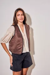 Chaleco sin mangas de corte al cuerpo, color negro con bordados florales en hilo contrastante. Presenta un diseño abierto con terminaciones reforzadas.