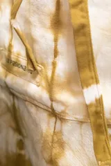 Delantal corto de algodón color crudo con teñido artesanal shibori en tonos marrones.