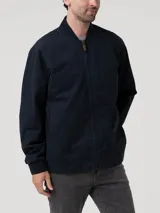 Chaqueta tipo bomber azul marino, con cuello, puños y dobladillo elásticos. Cierre frontal con cremallera y logo bordado en el pecho.