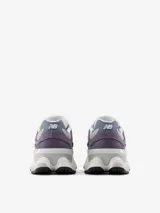 Championes urbanos New Balance serie 9060, con diseño robusto en tonos gris y violeta. Confeccionados en una combinación de gamuza, malla y materiales sintéticos. Presentan una entresuela gruesa con tecnología ABZORB para una amortiguación superior y suela de goma con excelente tracción.