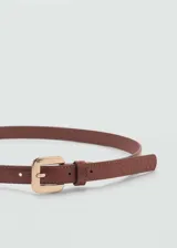 Cinturón fino de mujer con textura efecto piel de cocodrilo y hebilla metálica dorada.