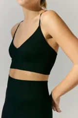 Top deportivo de tejido acanalado con escote en V y breteles finos regulables. Diseño sin costuras con ajuste al cuerpo.