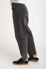 Jean de corte baggy con tiro medio, confeccionado en denim de color gris lavado. Presenta un diseño de pierna ancha con costuras horizontales a la altura de la rodilla y cierre frontal con botón y cremallera.