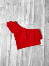 Top corto con un solo hombro y volado grande.