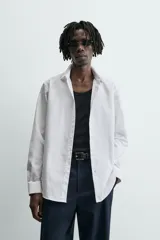 Camisa slim fit blanca de manga larga, cuello italiano y puños con botón. Cierre frontal de botonadura.