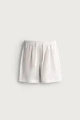 Bermuda de lino negro de corte relaxed fit, con cintura elástica ajustable mediante cordón y bolsillos frontales.