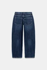 Pantalón de jean estilo baggy balloon de tiro medio, con diseño de cinco bolsillos y costuras laterales torcidas. Cuenta con cierre frontal de cremallera y botón metálico.
