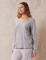Remera de pijama gris de algodón, con escote redondo, bolsillo en el pecho y mangas largas.