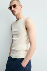 Camiseta sin mangas slim fit color crema, confeccionada en tejido de algodón elástico, con cuello redondo y ribetes en contraste color beige.