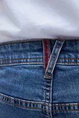 Jean de calce slim fit, color azul medio, con bolsillos delanteros y traseros.