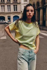 Camiseta de corte regular fit, cuello redondo y manga corta, confeccionada en una mezcla de algodón y lino. Presenta un diseño a rayas horizontales en tonos verdes y amarillos, con paneles laterales y mangas que combinan rayas verticales.