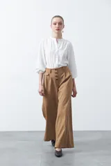 Pantalón wide leg de tiro alto color marrón, con caída fluida y silueta amplia. Presenta cintura alta con botonadura frontal visible y bolsillos laterales.