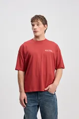 Remera boxy de algodón color negro, con diseño estampado en la espalda que incluye texto y el logo de la marca.