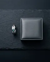Anillo de acero inoxidable con banda central esmaltada en efecto tornasolado, de diseño moderno y acabado pulido.