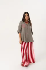 Camisa verde de silueta oversize con cuello camisero y manga 3/4. Tiene bordados de coral y caracol en el frente y botones a tono.