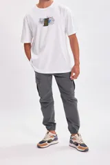 Pantalón cargo estilo jogger color gris oscuro, con bolsillos laterales tipo cargo y puños elásticos en los tobillos. Confeccionado con elastano para mayor comodidad y ajuste.