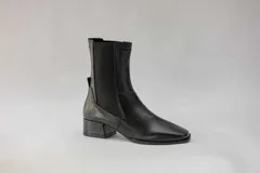 Botas de cuero color beige con elásticos laterales negros, taco cuadrado y punta cuadrada.