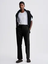 Pantalón de vestir negro de tela suave con pinzas delanteras, cintura elástica lateral y corte recto.