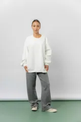 Buzo oversize de cuello redondo, confeccionado en algodón suave con interior frizado. Presenta un diseño de líneas simples, corte relajado y mangas largas con puños ajustados.