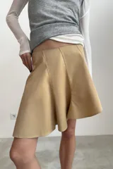Falda corta de tiro medio con diseño asimétrico en el bajo y cierre lateral con cremallera oculta.