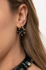 Aro tipo argolla de acero quirúrgico con mostacillas negras y doradas entrelazadas alrededor de toda la estructura.