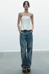 Top color amarillo claro, sin mangas y con escote recto. El bajo tiene un acabado peplum.