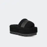 Sandalias UGG Fluffita Clear color negro, con plataforma plana y suela translúcida. Tienen una correa ajustable y plantilla contorneada. Forradas con mezcla de lana UGGplush™ y logo gráfico.