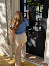 Pantalón sastrero de lino color beige, de tiro alto y pierna ancha. Presenta costuras en contratono y un bordado de caballo en el bolsillo trasero.