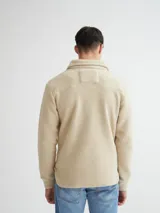 Camisaco color beige confeccionado en sherpa (corderito) con cartera de botones de pasta a tono y bolsillos con solapa en pecho.