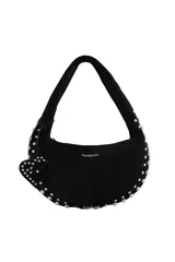 Cartera tipo hobo de gamuza color bordó, con diseño de media luna, decorada con tachas metálicas plateadas en los bordes y un dije colgante en forma de corazón con tachas. Cuenta con cierre superior y logo de la marca grabado en el frente.