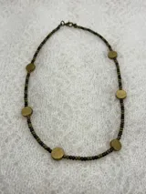 Gargantilla de cuentas pequeñas color marrón oscuro y apliques circulares dorados.