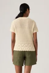 Sweater de punto color crudo, con tejido calado, manga corta y cuello redondo acanalado.