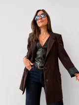 Blazer sastrero color marrón chocolate, de corte clásico con hombreras, botones frontales y bolsillos funcionales. Cuenta con forrería interna y mangas con vuelta.