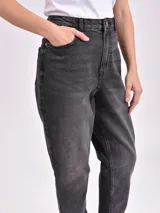 Jean de corte mom color negro gastado, tiro alto y diseño de pernera cónica.