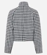 Saco corto estructurado con estampado pied de poule en blanco y negro. Presenta cuello alto, cierre frontal cruzado con botones decorativos y mangas largas.