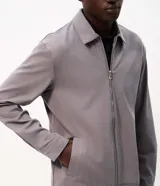 Campera Marfinno para hombre, de sarga texturizada color gris, corte regular, cuello camisero, cierre frontal con cremallera y bolsillos laterales embutidos.