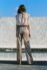 Pantalón palazzo plateado brillante de tiro alto con cintura elástica y cierre trasero invisible.