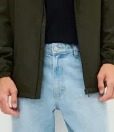 Pantalón de jean con corte recto y tiro medio, diseño clásico de cinco bolsillos con cierre de botón y cremallera. Confeccionado en algodón resistente.