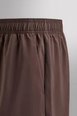 Pantalones deportivos cortos de tejido técnico ligero y elástico, con cintura elástica ajustable, bolsillos frontales y aberturas laterales en el bajo.