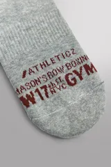 Pack de dos pares de calcetines de algodón jaspeado gris, con talón y puntera en color bordó. Presentan un bordado de un guante de boxeo en la caña y texto jacquard en la planta del pie.