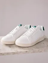 Championes blancos de cuero sintético con detalles en verde en el talón y la lengüeta.
