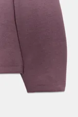 Jersey de cuello redondo y manga larga, confeccionado en tejido de punto elástico con trama compacta. Presenta un diseño con pinzas en la cintura que le otorgan una silueta entallada.