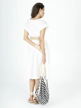 Vestido midi blanco de lino, con escote en V, mangas cortas y cinturón de soga con hebilla circular.