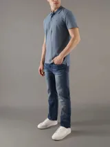 Chomba de piqué azul con cuello polo y tapeta de tres botones. Tiene mangas cortas, corte relaxed y logo de Calvin Klein bordado en el pecho. Confeccionada en algodón.