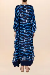 Kaftán largo con estampado abstracto en tonos azules y negros, con mangas amplias y escote en V con recogido frontal.