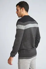 Sweater de punto con diseño de franjas horizontales en tonos negro y gris, cuello redondo, mangas largas y puños con detalle de rayas finas.