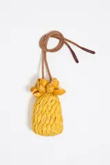 Colgante para bolso con forma de ananá tejido en rafia color amarillo, con hojas de caracoles y cordón marrón.