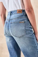 Pantalón jean celeste de corte recto, tiro medio y largo cropped.