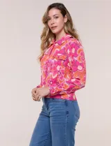 Camperita liviana de silueta entallada, con estampado floral en tonos azules, cuello camisero, cierre frontal con botones y bolsillos en el pecho.