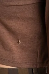 Polera de manga larga color marrón jaspeado, con cuello alto y corte ajustado al cuerpo.